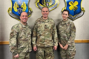 Three smiling Airmen pose for photo
