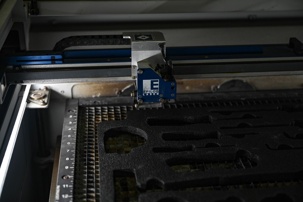 A laser engraver prepares to cut out new foam inserts