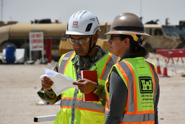 U.S. Army Col. Mohammed Z. Rahman, U.S. Army Corps of Engineers Transatlantic Expeditionary District commander (left), and Doriann Buzzetta, Construction Branch project engineer (right), review information during a site visit at Camp Buehring, Kuwait, Apr. 8, to review the Tactical Equipment Maintenance Facility project, demonstrating USACE’s dedication to maintaining operational excellence and ensuring project success for strategic infrastructure crucial for sustaining military capability.