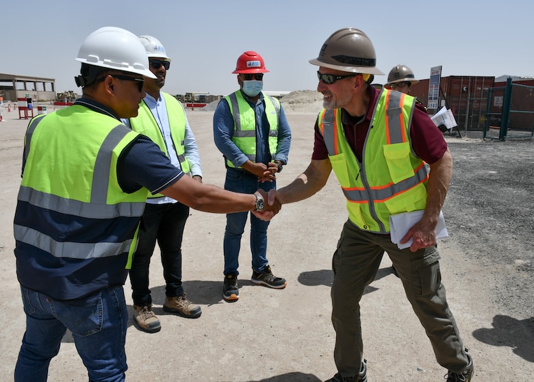 Russell Wahlay, U.S. Army Corps of Engineers Transatlantic Expeditionary District construction chief (right), shakes hands with a contracting team member during a site visit at Camp Buehring, Kuwait, Apr. 8, to review the Tactical Equipment Maintenance Facility project, demonstrating USACE’s dedication to maintaining operational excellence and ensuring project success for strategic infrastructure crucial for sustaining military capability.
