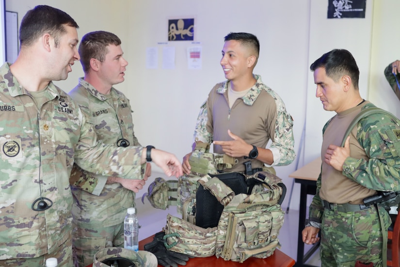 Maj. Ryan Hubbs and Staff Sgt. Mason Graves discuss combat uniforms with Ecuador partners during a subject matter expert exchange on urban operations at Latacunga, Ecuador, March 19, 2024.