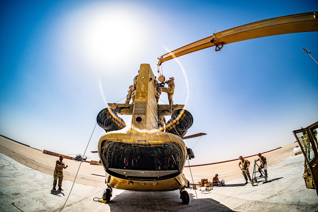Soldiers conduct maintenance on a military helicopter.