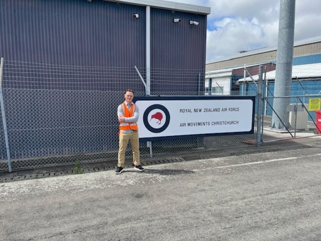 Ensign Jonathan Myette in front of sign at Royal New Zealand Air Force's Air Christchurch.