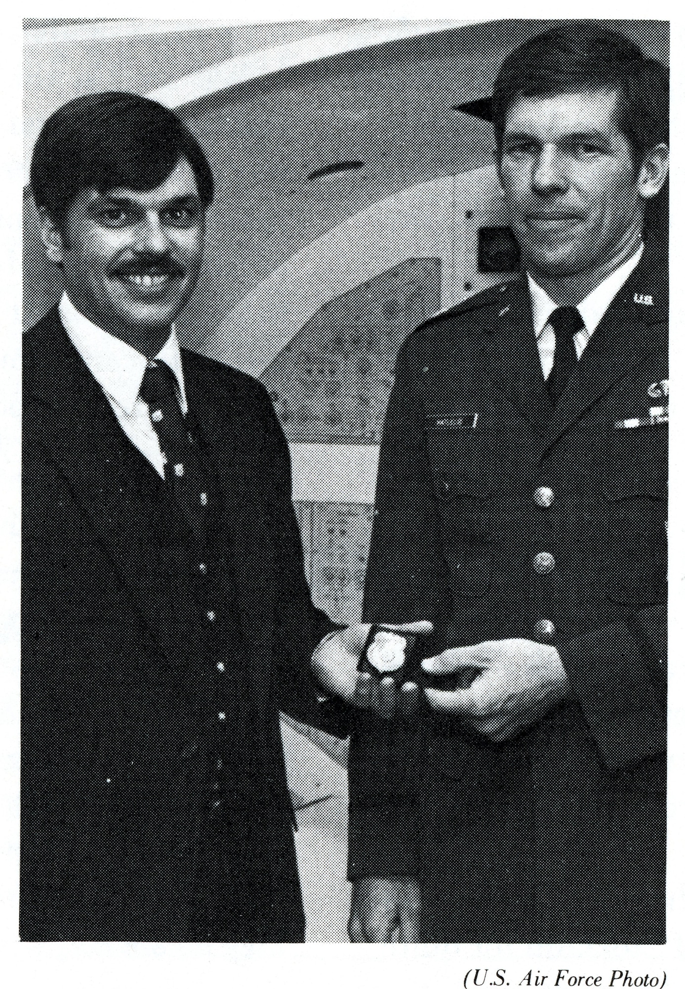 Special Agent Warren Woerner (left), OSI Detachment 1402, presents Badge Number 1 to Major John Hatlelid (right), Air Force Academy Project Officer on September 17, 1982.