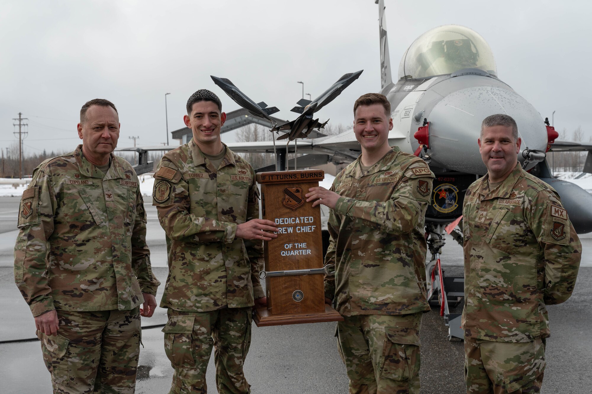 Airmen pose for a photograph for winning the Dedicated Crew Chief award following a load competition at Eielson Air Force Base, Alaska, April 5, 2024.