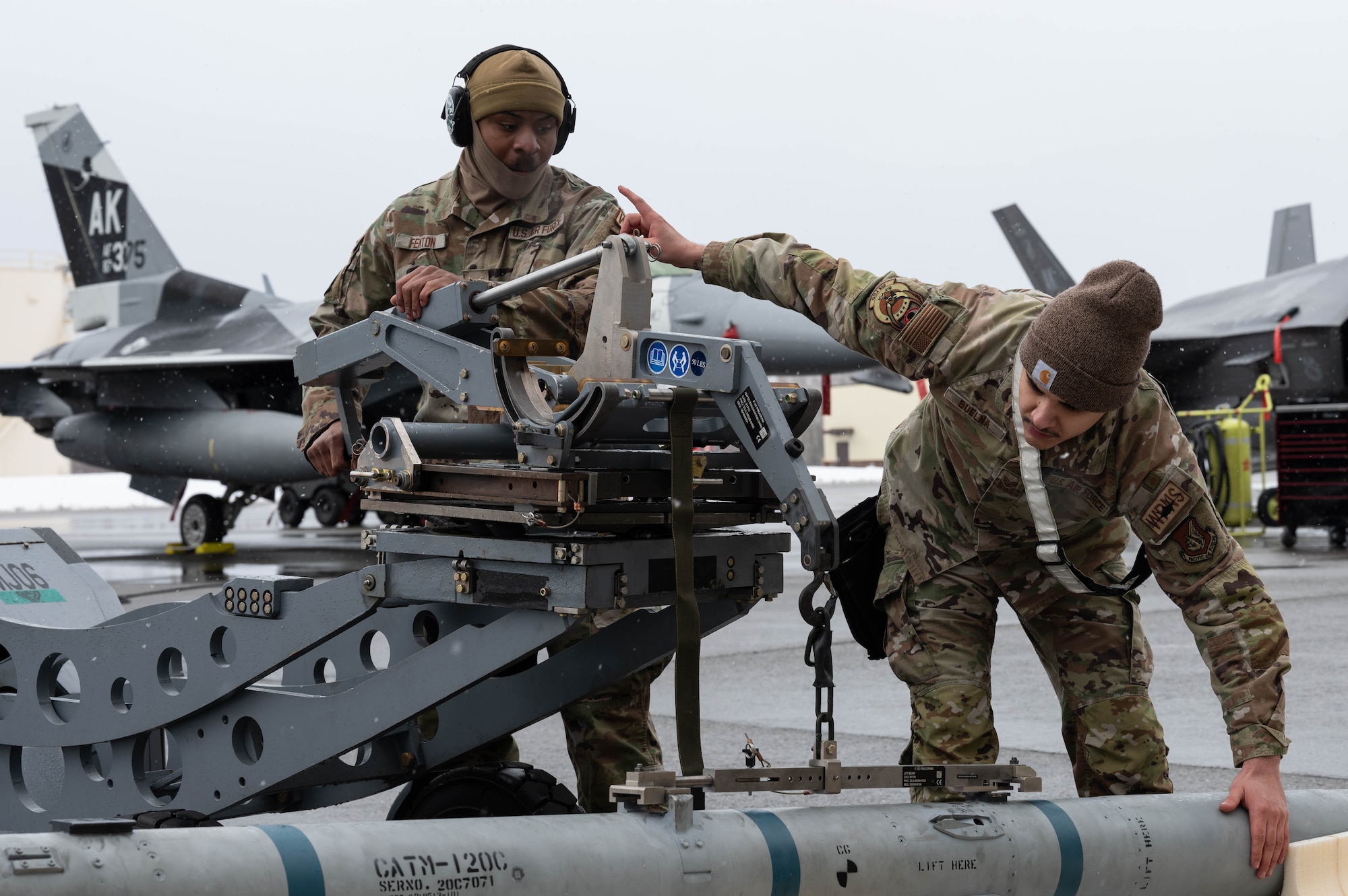 U.S. Air Force Senior Airman Felix Fenton, 355th Fighter Generation Squadron load crew team member, left, and Staff Sgt. Sergio Buelna, 355th FGS load crew team chief, prepare munitions for loading during a load competition at Eielson Air Force Base, Alaska, April 5, 2024.