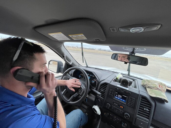 Man holding phone while honking horn in truck.