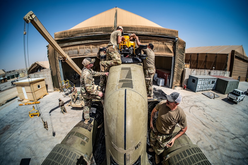 Soldiers repair a military helicopter.