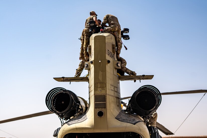 Soldiers repair a military helicopter.