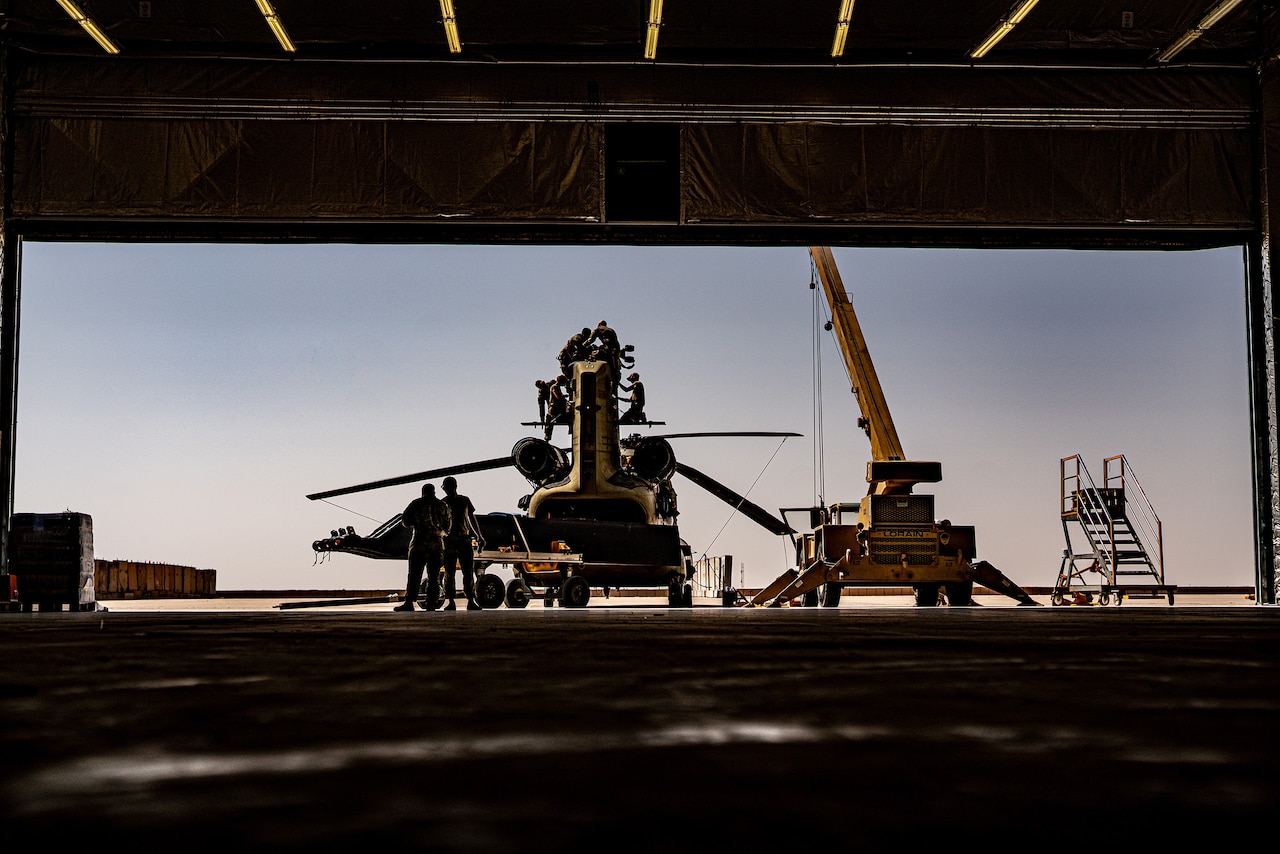 Soldiers repair a military helicopter.