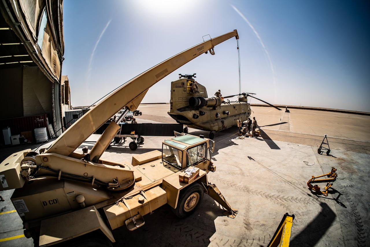 Soldiers repair a military helicopter.
