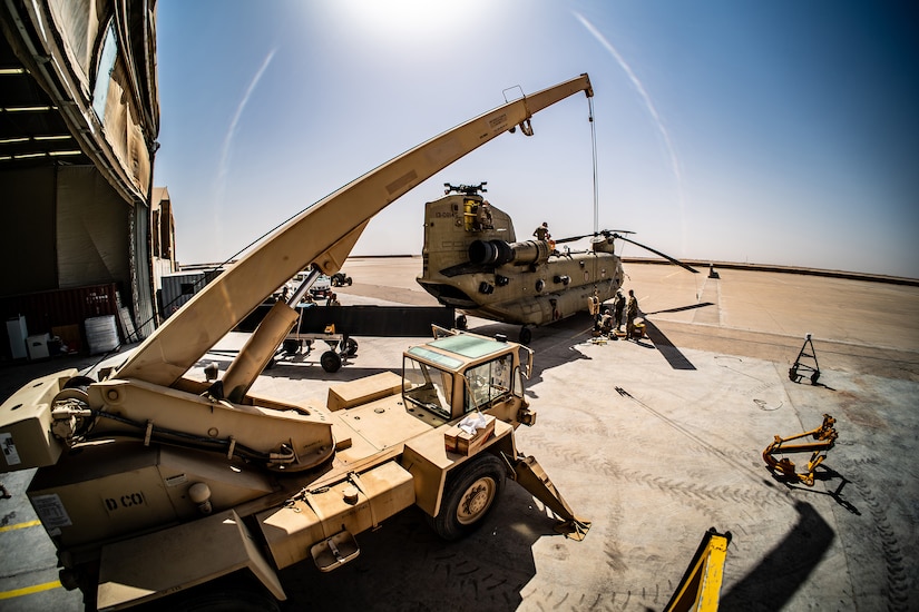 Soldiers repair a military helicopter.