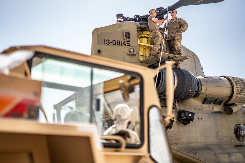 Soldiers repair a military helicopter.