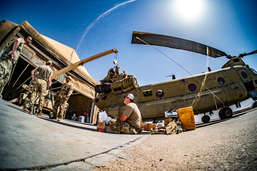 Soldiers repair a military helicopter.