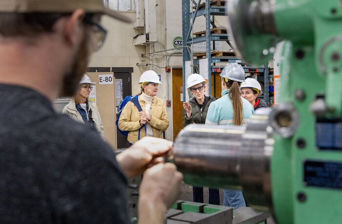 Felicienne Griffin, superintendent, Shop 31, Inside Machinists, conducts a tour of Building 431, March 28, 2024, for three founding members of "The Band of Sisters," including (from left) Cie Nicholson, Lori Tauber and Angelique Bellmer-Krembs, at Puget Sound Naval Shipyard & Intermediate Maintenance Facility in Bremerton, Washington. (U.S. Navy photo by Wendy Hallmark)