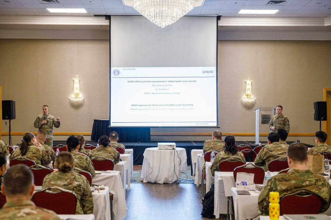 Image of Airmen speaking to a group of people.