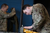 Airman 1st Class Thomas Morais, a 5th Operations Support Squadron aircrew flight equipment apprentice, ensures that all flight and safety equipment is in perfect working order during Prairie Vigilance 24-3 at Minot Air Force Base, North Dakota, April 8, 2024. These exercises enable crews to maintain a high state of readiness and proficiency, while validating the always-ready, global strike capability. (U.S. Air Force photo by Airman 1st Class Trust Tate)