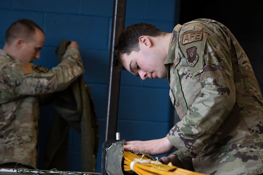 Airman 1st Class Thomas Morais, a 5th Operations Support Squadron aircrew flight equipment apprentice, ensures that all flight and safety equipment is in perfect working order during Prairie Vigilance 24-3 at Minot Air Force Base, North Dakota, April 8, 2024. These exercises enable crews to maintain a high state of readiness and proficiency, while validating the always-ready, global strike capability. (U.S. Air Force photo by Airman 1st Class Trust Tate)