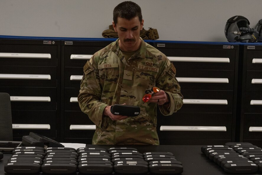 Airman 1st Class Jacob Ueda, 5th Operations Support Squadron aircrew flight equipment apprentice, ensures a pair of aircrew laser eye protection (ALEP) glasses is free from scratches and holds a tinted reflection, during Prairie Vigilance 24-3 at Minot Air Force Base, North Dakota, April 8, 2024. Prairie Vigilance serves to ensure Allies and partners that the U.S. is ready to execute nuclear options and global strike anytime, anywhere, in order to deter and, if necessary, respond to strategic attack. (U.S. Air Force photo by Airman 1st Class Trust Tate)