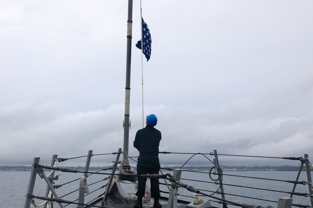 Boatswain’s Mate 3rd Class Joshua Lopez raising the union jack during a sea and anchor detail aboard the Arleigh Burke-class guided-missile destroyer USS Howard (DDG 83)