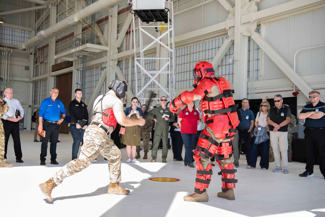 Airmen demonstrate defensive tactics in front of a large group of people