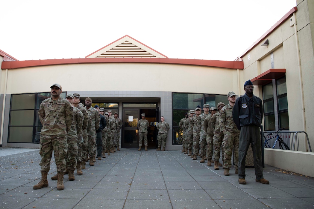 Airmen stand in  formation in two lines