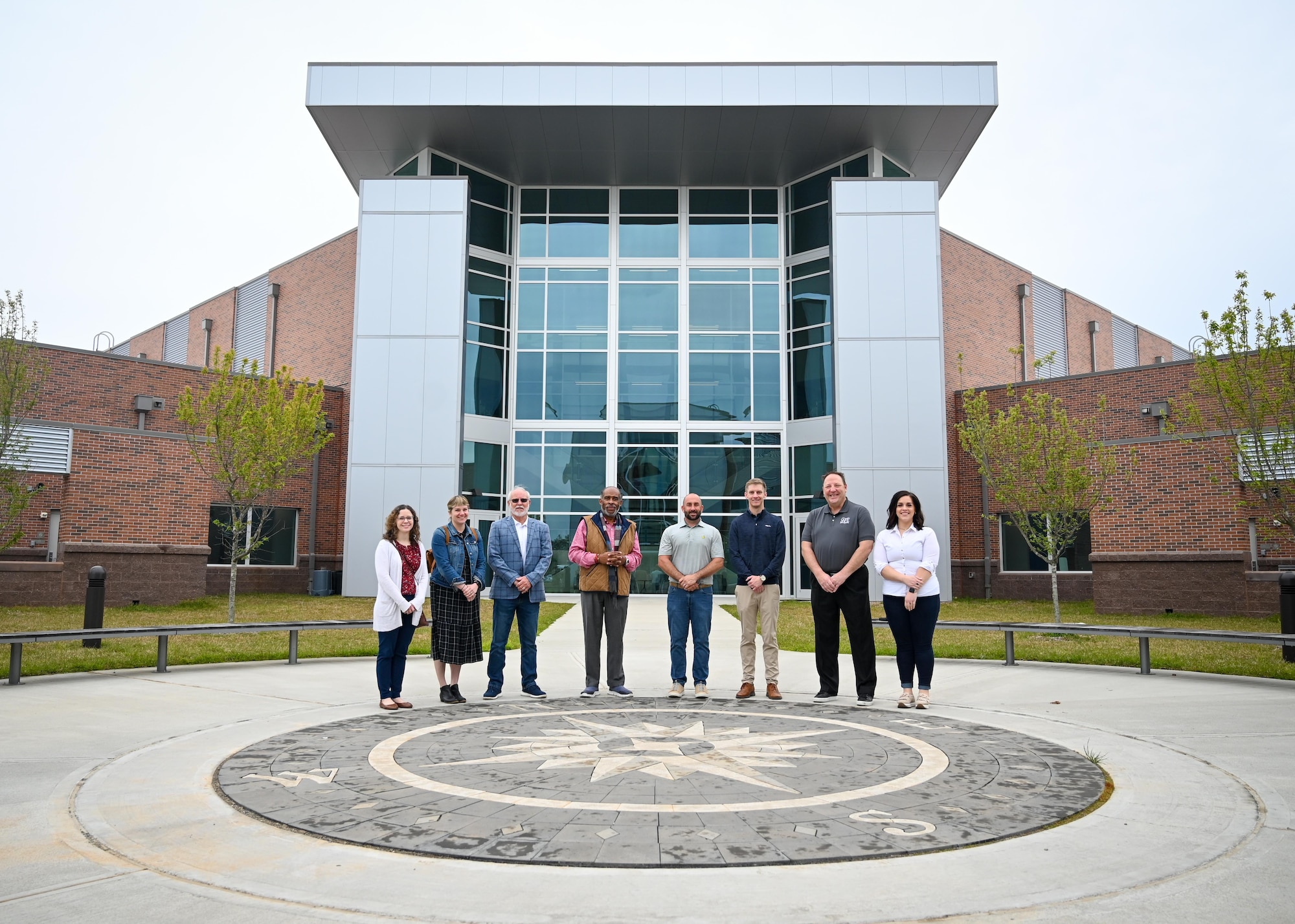 Honorary commanders pose for a group photo in front of the new building.