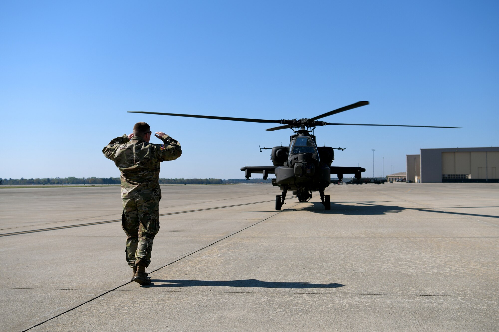 U.S. Army Sgt. Zack McGehee, 1-151st Attack Reconnaissance Battalion, South Carolina Army National Guard AH-64E Apache Guardian helicopter crew chief, marshals an AH-64E on the flightline at Shaw Air Force Base, S.C., March 21, 2024. The AH-64Es landed at Shaw AFB prior to a joint forcible entry exercise in which they would be transported by a C-5M Super Galaxy to the training area in Florida. (U.S. Air Force photo by Staff Sgt. Kelsey Owen)