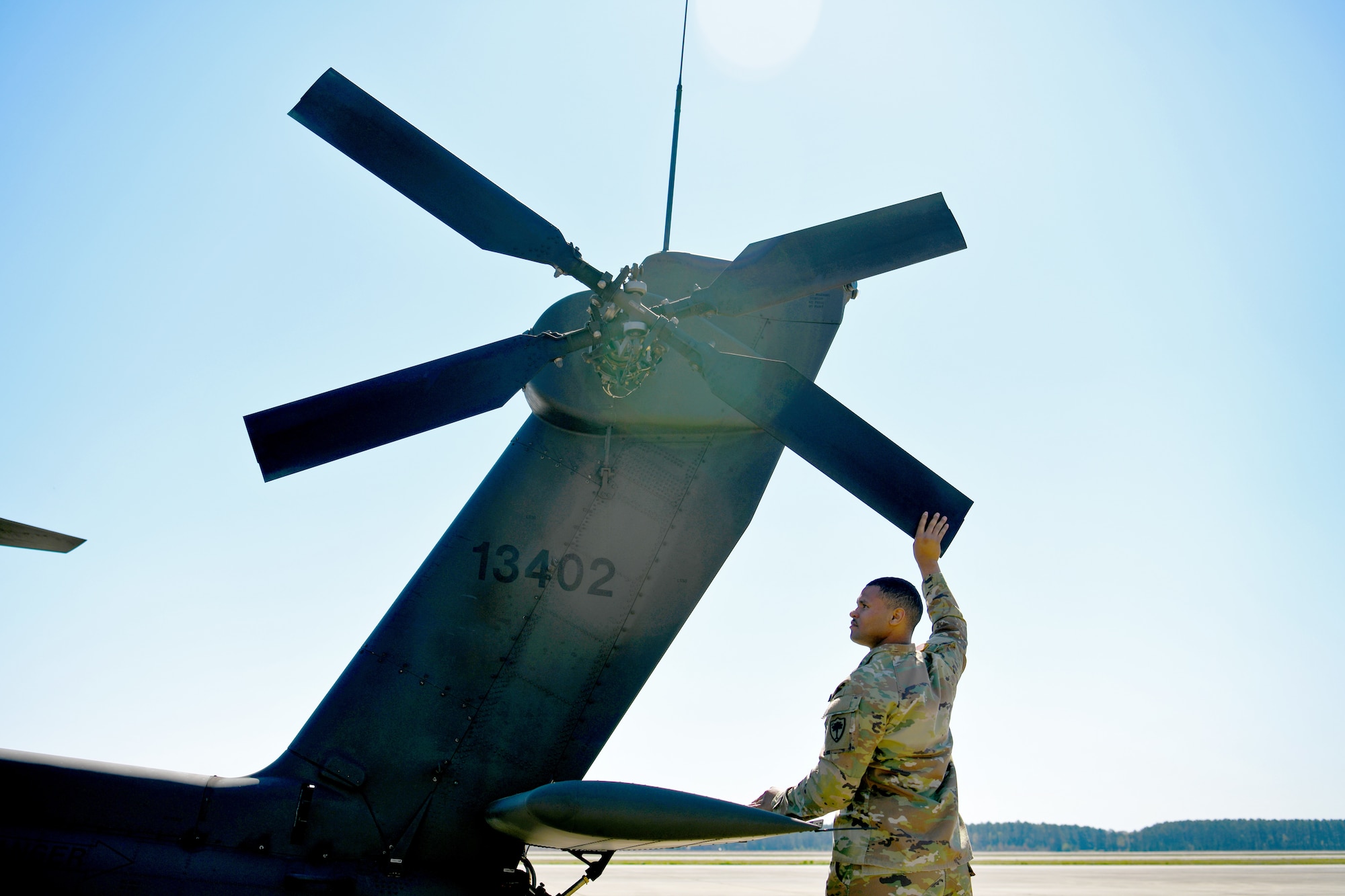 U.S. Army Staff Sgt. Devin Perry, 1-151st Attack Reconnaissance Battalion, South Carolina Army National Guard AH-64E Apache Guardian helicopter crew chief, adjusts the position of the rotors in preparation for loading onto a U.S. Air Force C-5M Super Galaxy at Shaw Air Force Base, S.C., March 21, 2024. The two-day process marked the first time U.S. Army AH-64Es were loaded into a C-5M at Shaw AFB. (U.S. Air Force photo by Staff Sgt. Kelsey Owen)