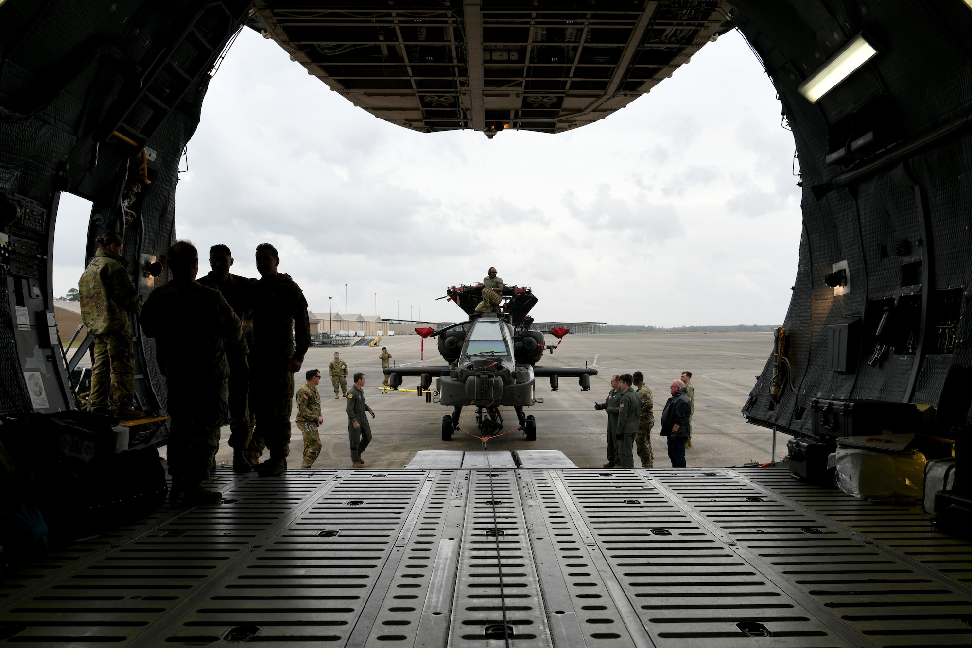 U.S. Airmen assigned to the 20th Logistics Readiness Squadron at Shaw Air Force Base, S.C., and the 337th Airlift Squadron from Westover Air Reserve Base, Mass., and U.S. Soldiers assigned to the 1-151st Attack Reconnaissance Battalion, South Carolina Army National Guard, prepare to load an AH-64E Apache Guardian helicopter onto a C-5M Super Galaxy at Shaw AFB, March 22, 2024. The two-day process was an exercise in coordination and teamwork between the services. (U.S. Air Force photo by Staff Sgt. Kelsey Owen)