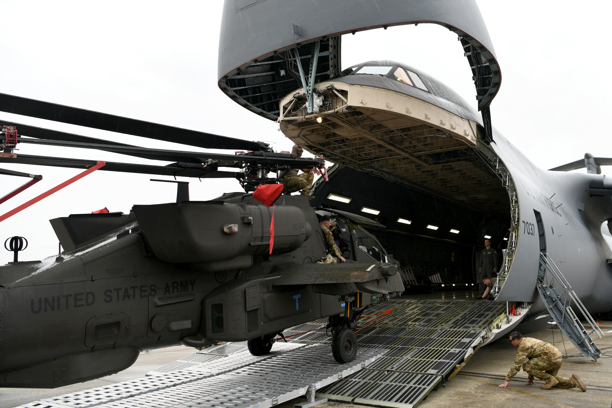 U.S. Airmen assigned to the 20th Logistics Readiness Squadron at Shaw Air Force Base, S.C., and the 337th Airlift Squadron from Westover Air Reserve Base, Mass., and U.S. Soldiers assigned to the 1-151st Attack Reconnaissance Battalion, South Carolina Army National Guard, load an AH-64E Apache Guardian helicopter onto a C-5M Super Galaxy at Shaw AFB, March 22, 2024. The two-day process was an exercise in coordination and teamwork between the services. (U.S. Air Force photo by Staff Sgt. Kelsey Owen)