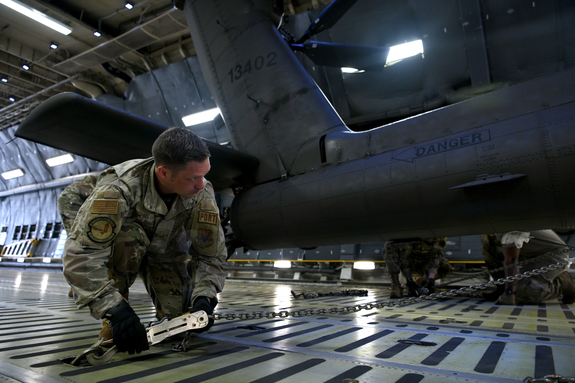 U.S. Air Force Tech. Sgt. Brandon Clemons, 20th Logistics Readiness Squadron air transportation specialist, secures an AH-64E Apache Guardian helicopter assigned to the U.S. Army 1-151st Attack Reconnaissance Battalion, South Carolina Army National Guard, inside a C-5M Super Galaxy assigned to the 337th Airlift Squadron from Westover Air Reserve Base, Mass., at Shaw Air Force Base, S.C., March 22, 2024. The two-day process marked the first time U.S. Army AH-64Es were loaded into a C-5M at Shaw AFB. (U.S. Air Force photo by Staff Sgt. Kelsey Owen)