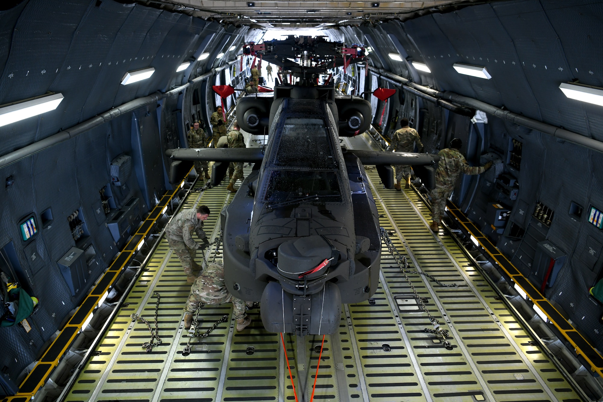 U.S. Airmen assigned to the 20th Logistics Readiness Squadron at Shaw Air Force Base, S.C., and the 337th Airlift Squadron from Westover Air Reserve Base, Mass., and U.S. Soldiers assigned to the 1-151st Attack Reconnaissance Battalion, South Carolina Army National Guard, secure an AH-64E Apache Guardian helicopter inside a C-5M Super Galaxy at Shaw AFB, March 22, 2024. The two-day process marked the first time U.S. Army AH-64Es were loaded into a C-5M at Shaw AFB. (U.S. Air Force photo by Staff Sgt. Kelsey Owen)