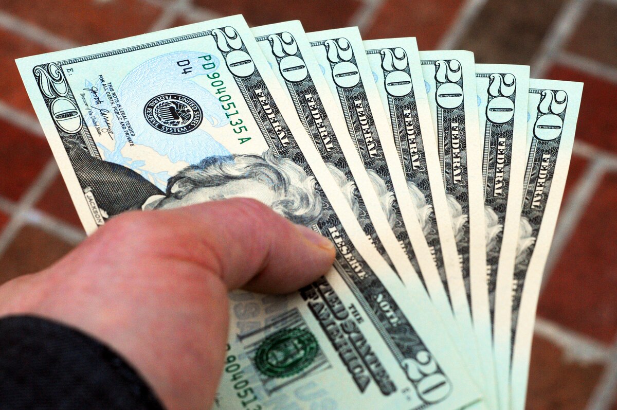 A hand holds cash.
