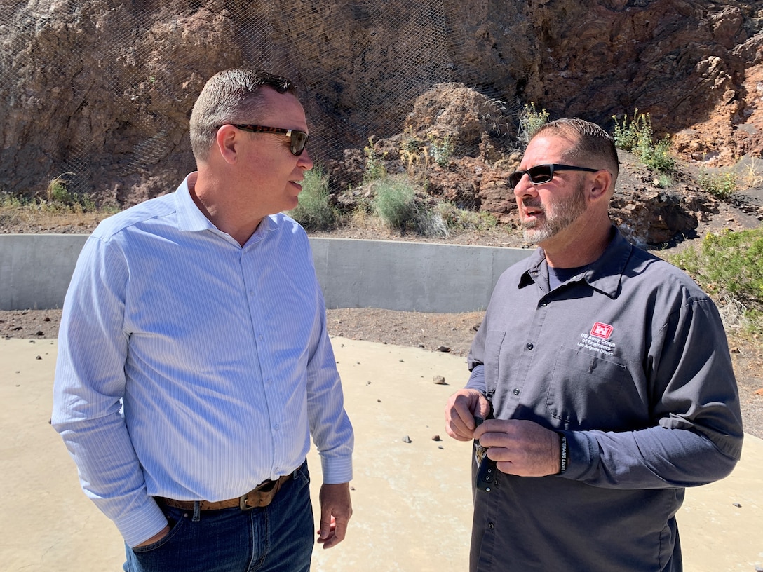 Michael Moran, a Painted Rock Dam operator, right, briefs Justin Gay, deputy district engineer for the Los Angeles District, during a tour of the Painted Rock Dam spillway March 25 near Gila Bend, Arizona. The U.S. Army Corps of Engineers built the spillway to keep flood waters from damaging the dam’s structure.