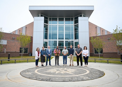 Honorary commanders pose for a group photo in front of the new building.