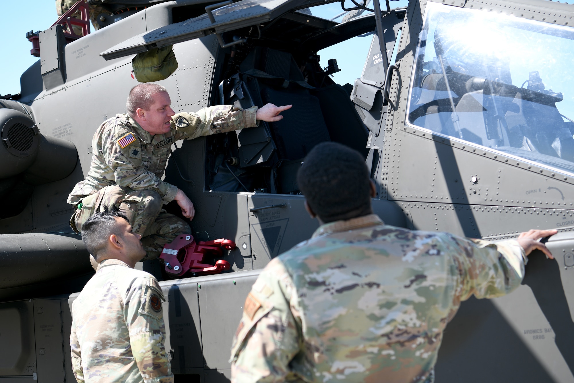 U.S. Army Staff Sgt. Fred Hiatt, 1-151st Attack Reconnaissance Battalion, South Carolina Army National Guard AH-64E Apache Guardian crew chief, explains the functions of an AH-64 to U.S. Airmen assigned to the 20th Logistics Readiness Squadron at Shaw Air Force Base, S.C., March 21, 2024. Several U.S. Air Force units at Shaw AFB were instrumental in mission success. (U.S. Air Force photo by Staff Sgt. Kelsey Owen)