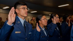 Security Forces technical training students raise their hands as they recite the Security Forces pledge during the Basic Defender Course graduation at Joint Base San Antonio-Lackland, Texas, Jan. 16, 2024. The 343rd Training Squadron is optimizing training to ensure Defenders are equipped with the skills and knowledge needed to tackle evolving threats in a modern era. The 343 TRS Security Forces technical training is one of the key components in the Defender Next initiative, where the career field is undertaking the largest shift in the schoolhouse in over two decades.  (U.S. Air Force photo by Vanessa R. Adame)
