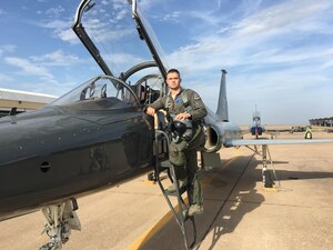 A pilot stands next to a T-38 jet.