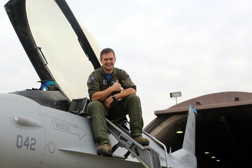 A pilot sits on a jet.