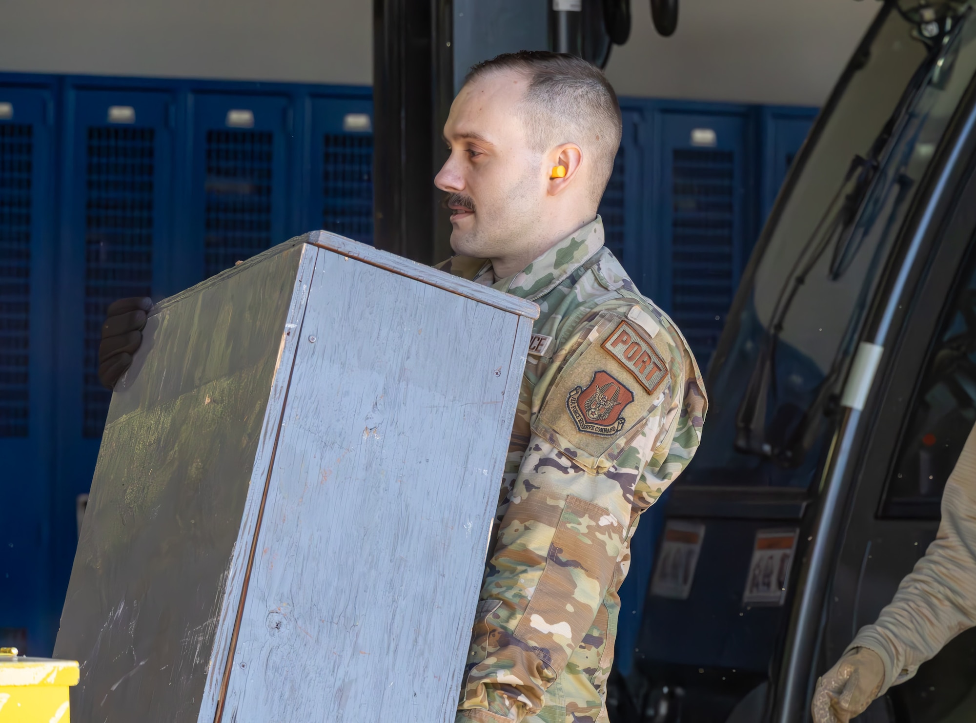 airman carrying a wooden box.