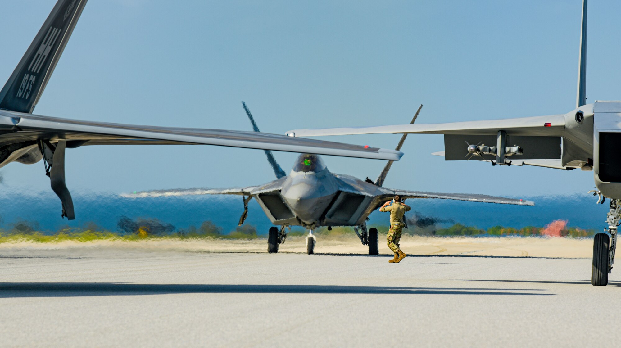 Airman marshals aircraft on a runway