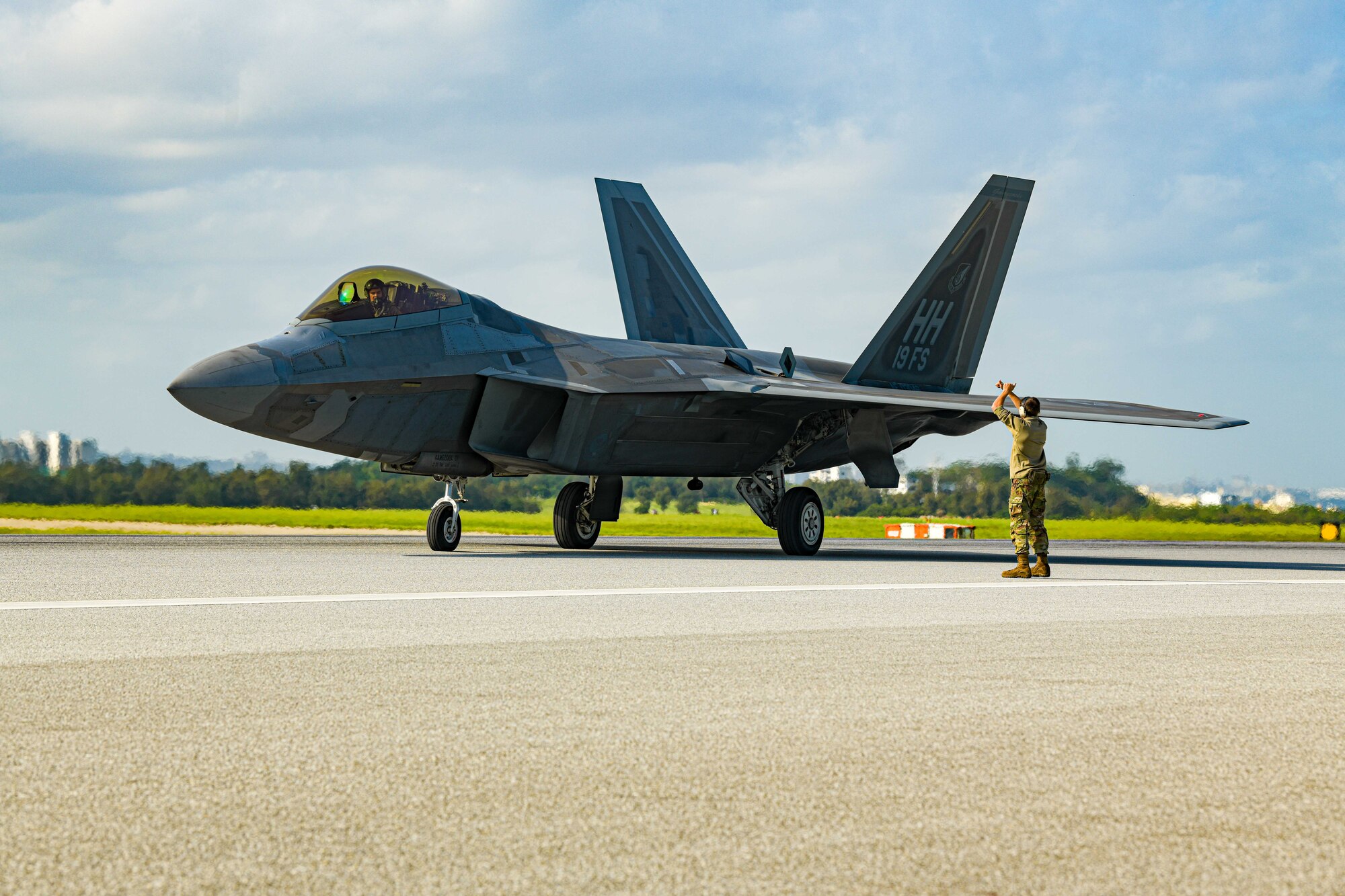 Airman marshals aircraft on a runway