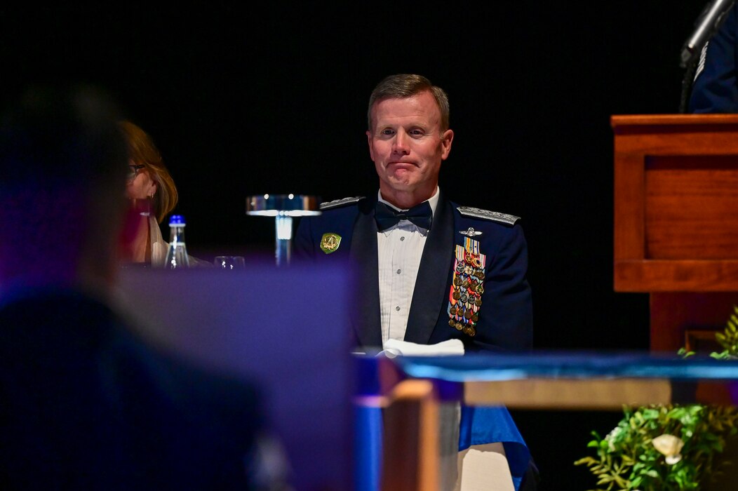 A uniformed man sits at a table is overcome with emotion