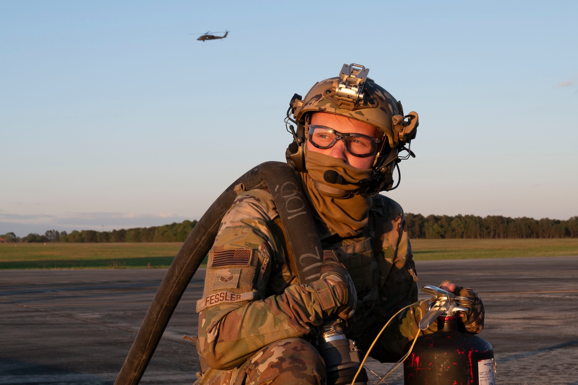 A person prepares to refuel a helicopter.