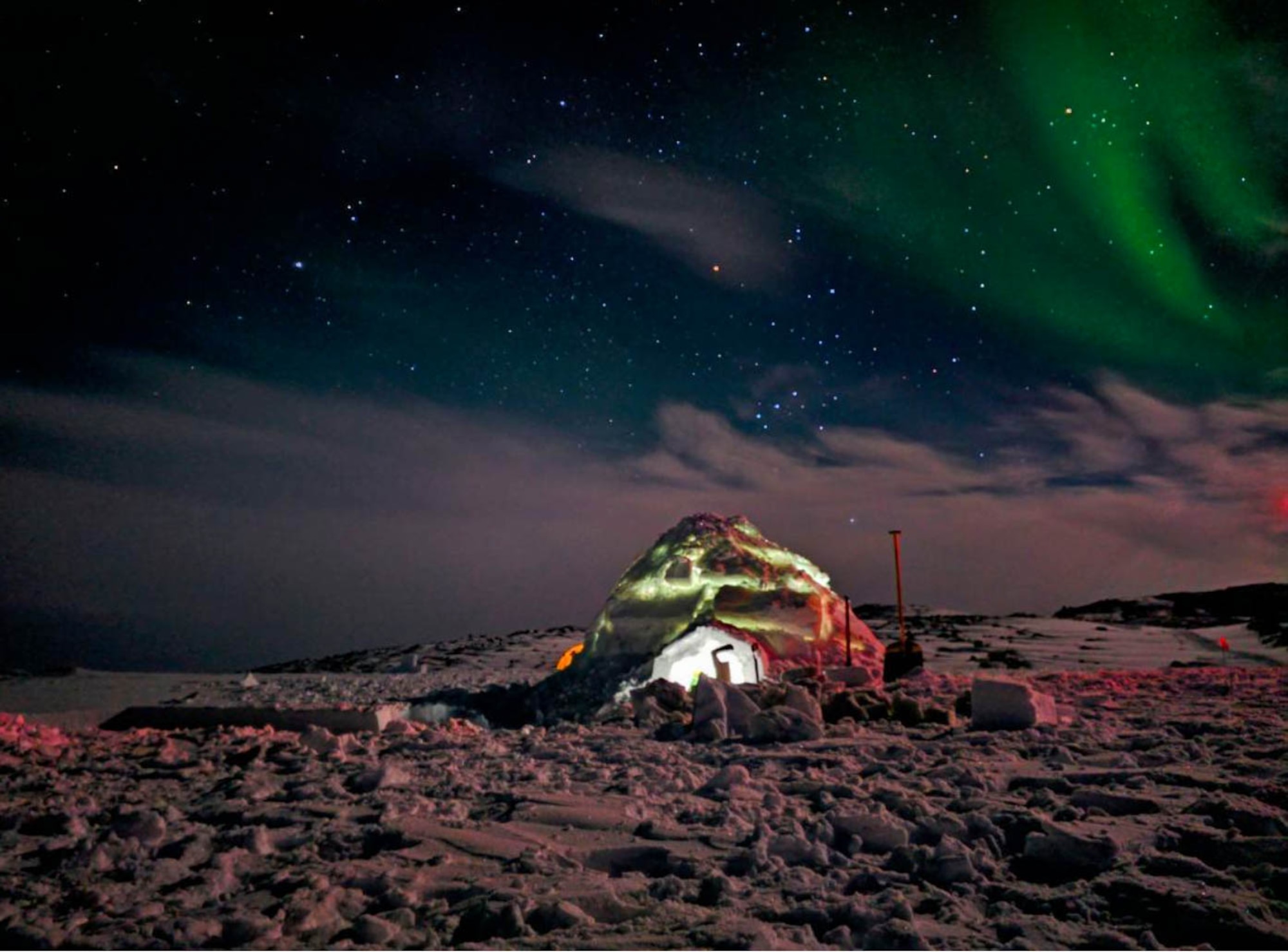 An igloo glows at night in Greenland.