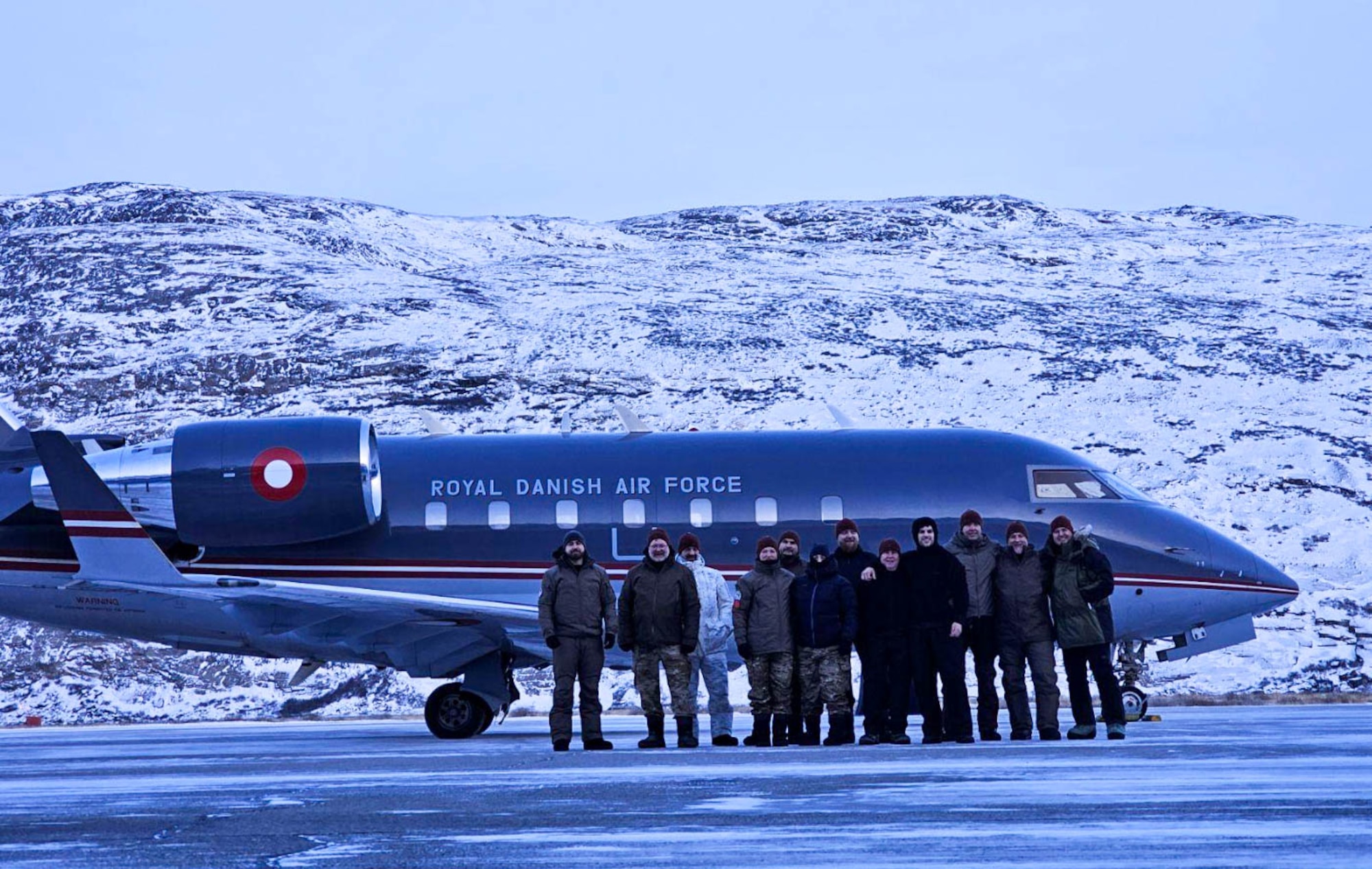 A group of military personnel stand for a photo during an Artic training event in Kangerlussuaq, Greenland.
