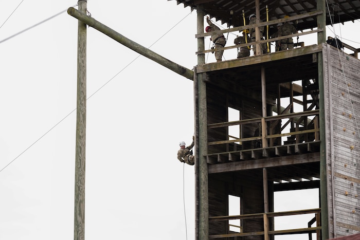 U.S. Air Force Officer Training School trainee, bottom, rappels down a wall during their Blue Thunder obstacle course training, at Maxwell Air Force Base, Alabama. Instructors at the top of the tower watch the trainee as they make their way down, to ensure the ropes remain secure and that all safety procedures are followed