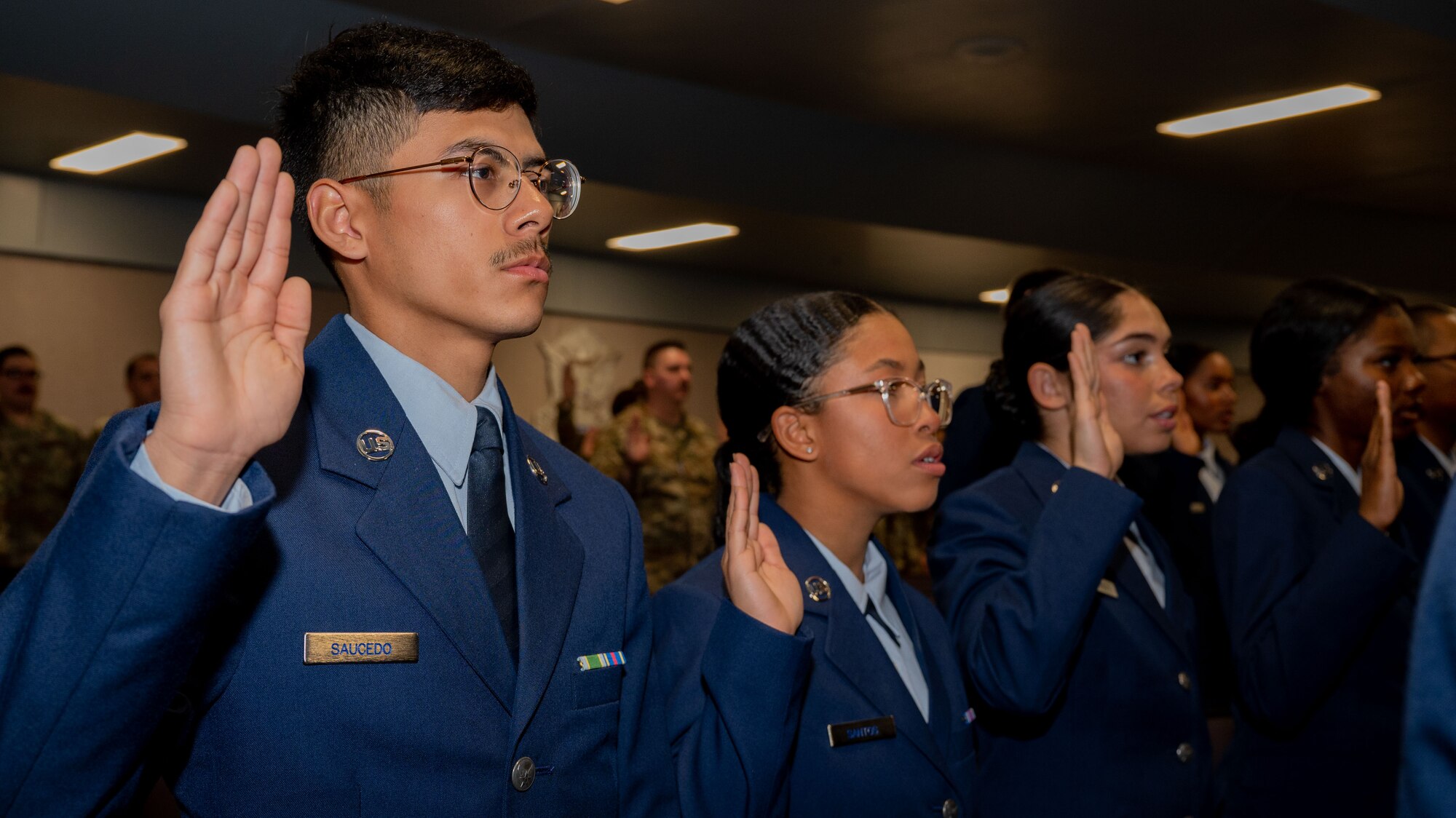 Security Forces technical training students raise their hands as they recite the Security Forces pledge during the Basic Defender Course graduation at Joint Base San Antonio-Lackland, Texas, Jan. 16, 2024. The 343rd Training Squadron is optimizing training to ensure Defenders are equipped with the skills and knowledge needed to tackle evolving threats in a modern era. The 343 TRS Security Forces technical training is one of the key components in the Defender Next initiative, where the career field is undertaking the largest shift in the schoolhouse in over two decades.  (U.S. Air Force photo by Vanessa R. Adame)