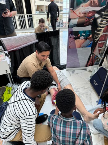 Team members from Walter Reed's Department of Simulation participate in the Navy League of the U.S. STEM Expo on April 7 at the Gaylord National Resort and Convention Center in Oxon Hill, Maryland. The Walter Reed Department of Simulation hosted a busy booth demonstrating CPR with real-time feedback, a [model] bleeding limb with a tourniquet to stop the bleed, medical moulage displays with explanations of how it relates to training, and a ventriloscope demonstrating normal and abnormal heart and lung sounds
